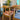 Four wooden dining chairs around a table in front of a houseplant