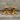Two wooden stools with a star-shaped base against a concrete wall.