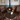 Two brown leather Chesterfield style arm chairs next to a fire place