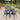 4 black plastic chairs around a black metal square table in a garden