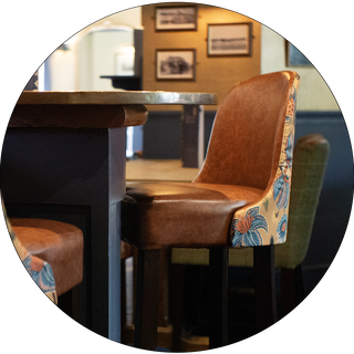 A Kenilworth bar chair with a light brown vinyl inner and yellow floral back