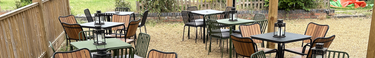 Multiple metal garden tables each with four chairs