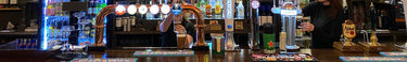 A bar front with a bartender pouring Guinness