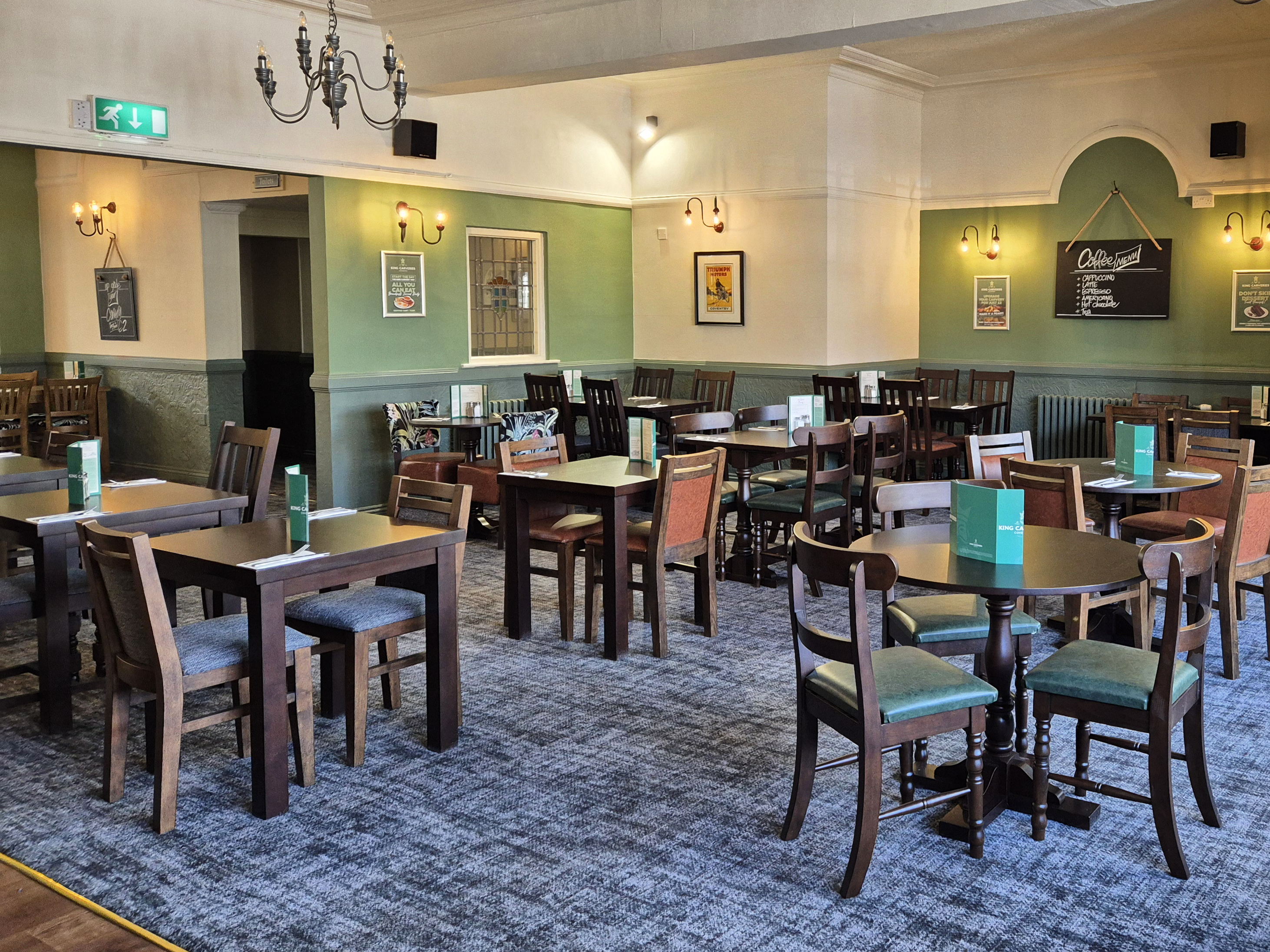 Dining area with tables, chairs, and decor in a pub setting.