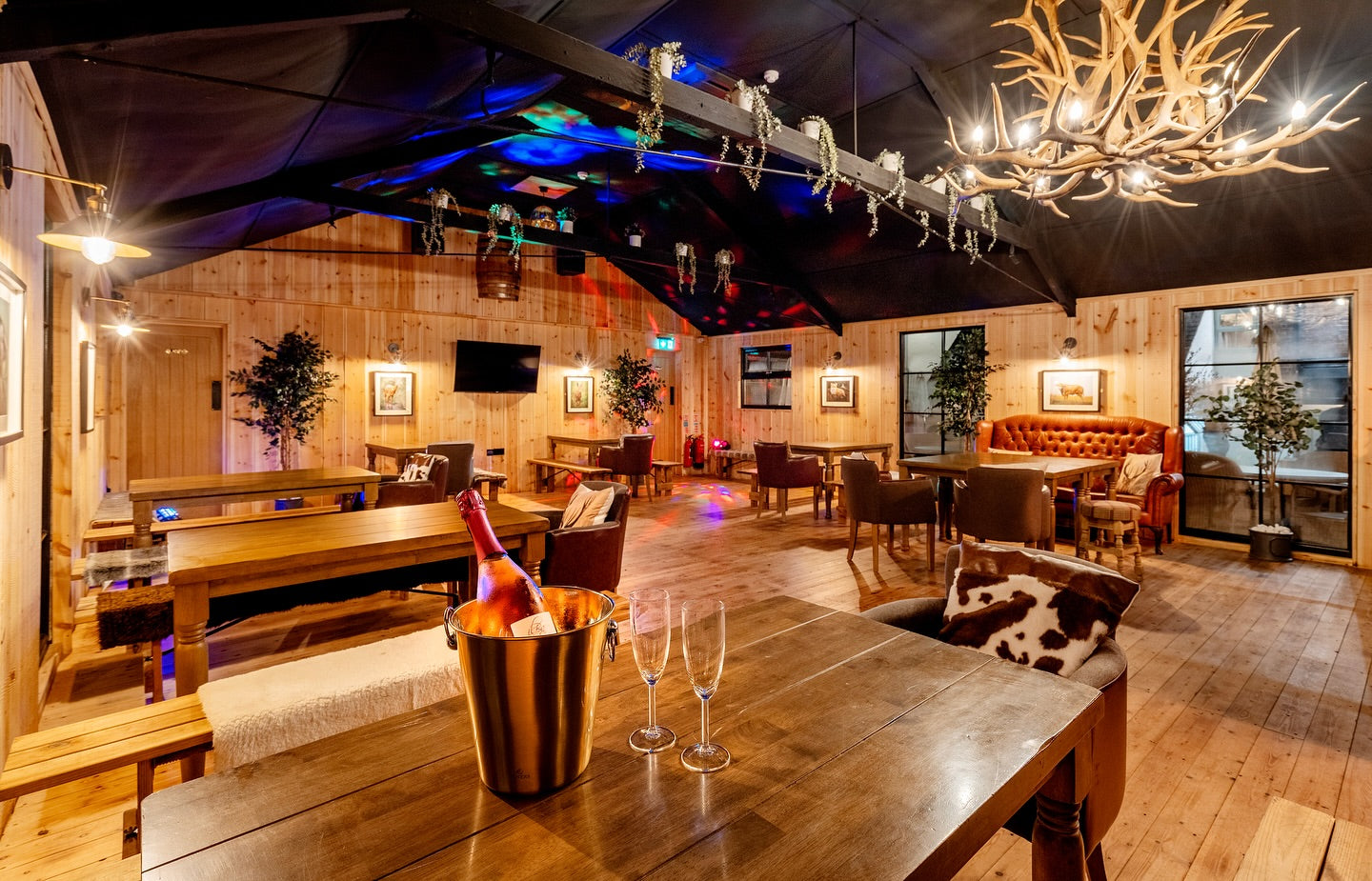 Luxurious interior of a restaurant with wooden decor, wine bottle, and glasses.