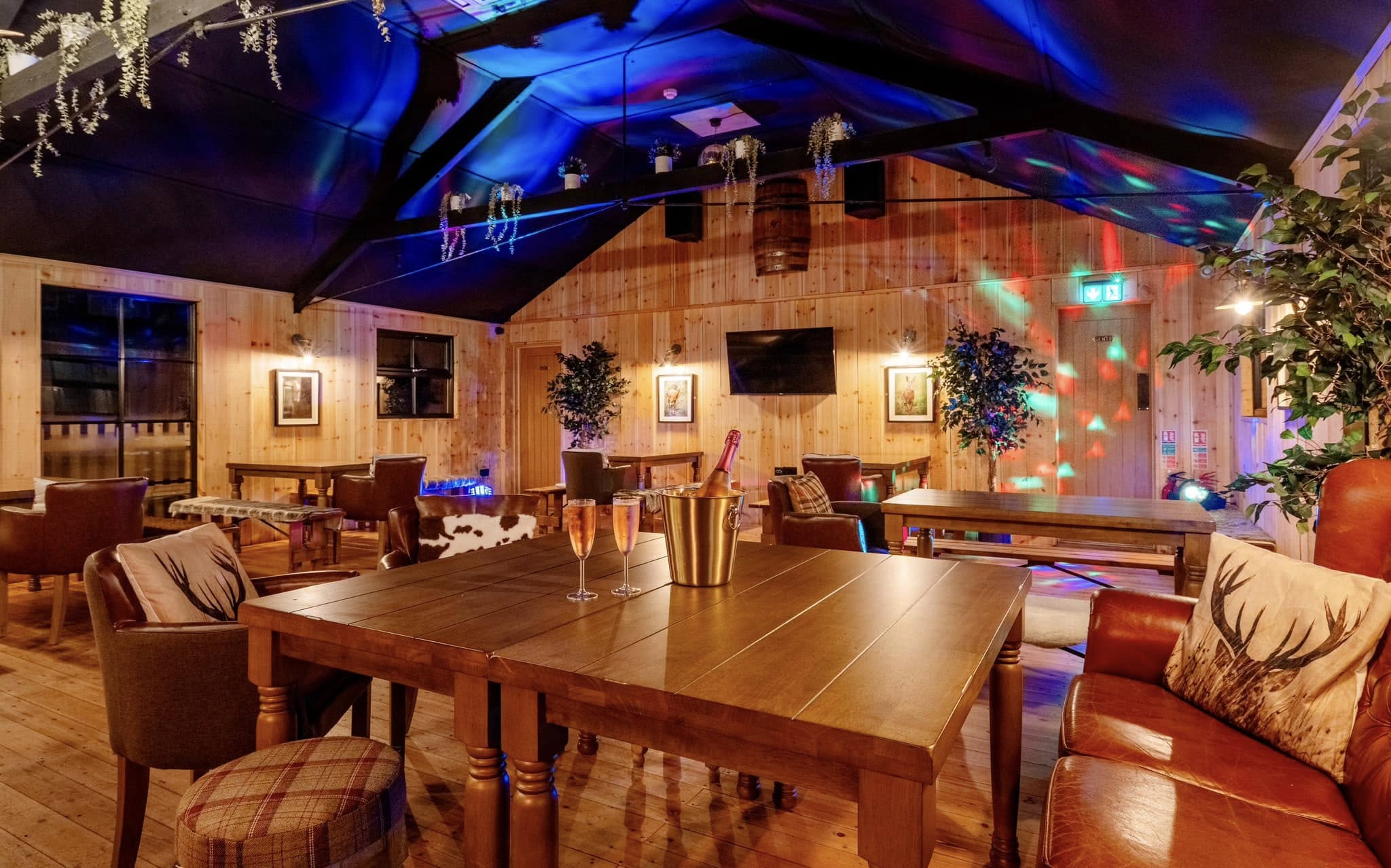 Interior of a bar or pub with wooden tables, chairs, and decorative elements.