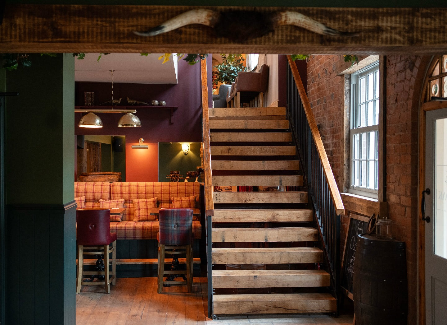 Staircase leading to an upper level with a bar area and window in the background.