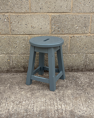 Blue stool against a concrete wall