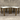Two wooden tables with white tops against a concrete wall.