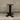 Dark metal table base against a gray brick wall