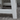 Close-up of a white wooden stool on a concrete floor