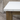Close-up of a wooden table with a white top against a stone wall background