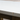 Close-up of a wooden table corner with a white top