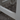 Close-up of a white metal bench with visible wear on a concrete surface
