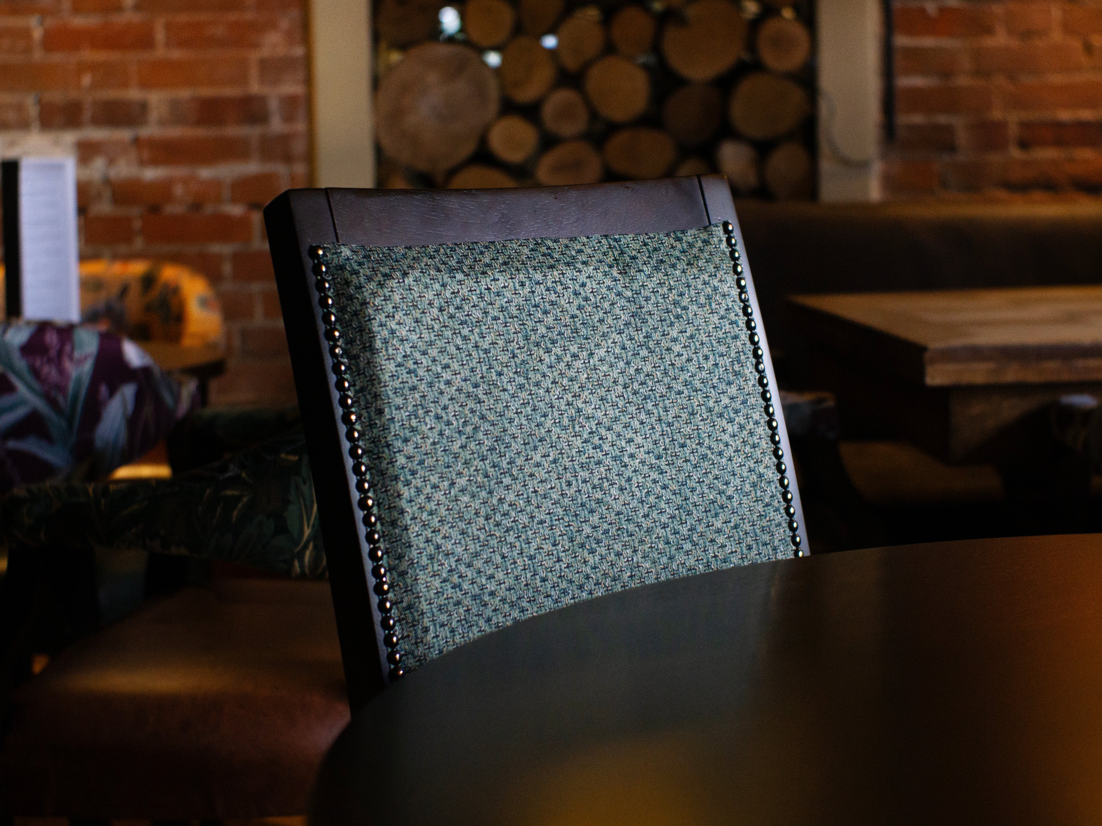 Up close of a dark walnut Modena with a blue/green fabric