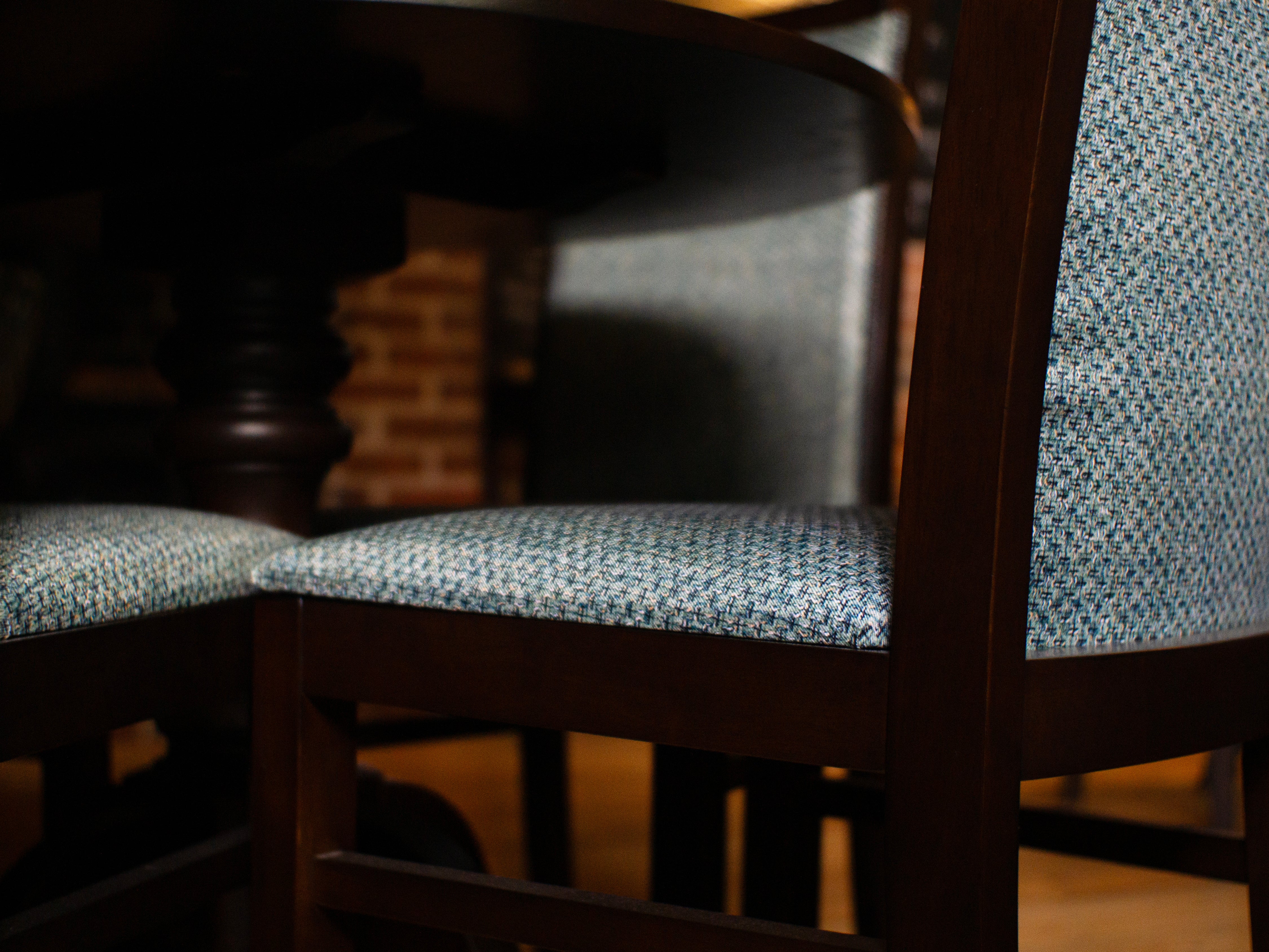 Up close of a dark brown chair with blue/white fabric