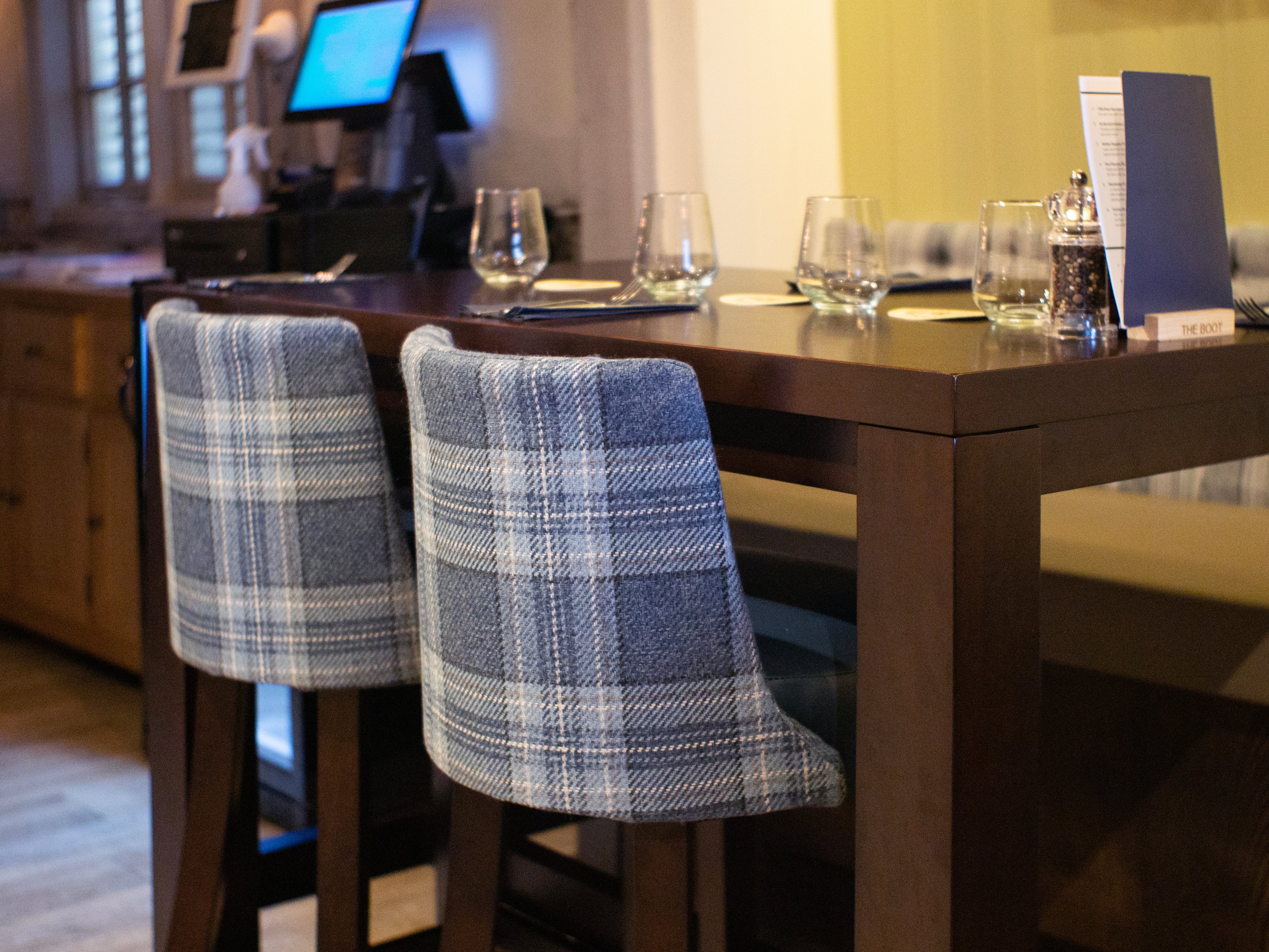 Up close of a Warwick bar chair and a Chunky H frame poseur table