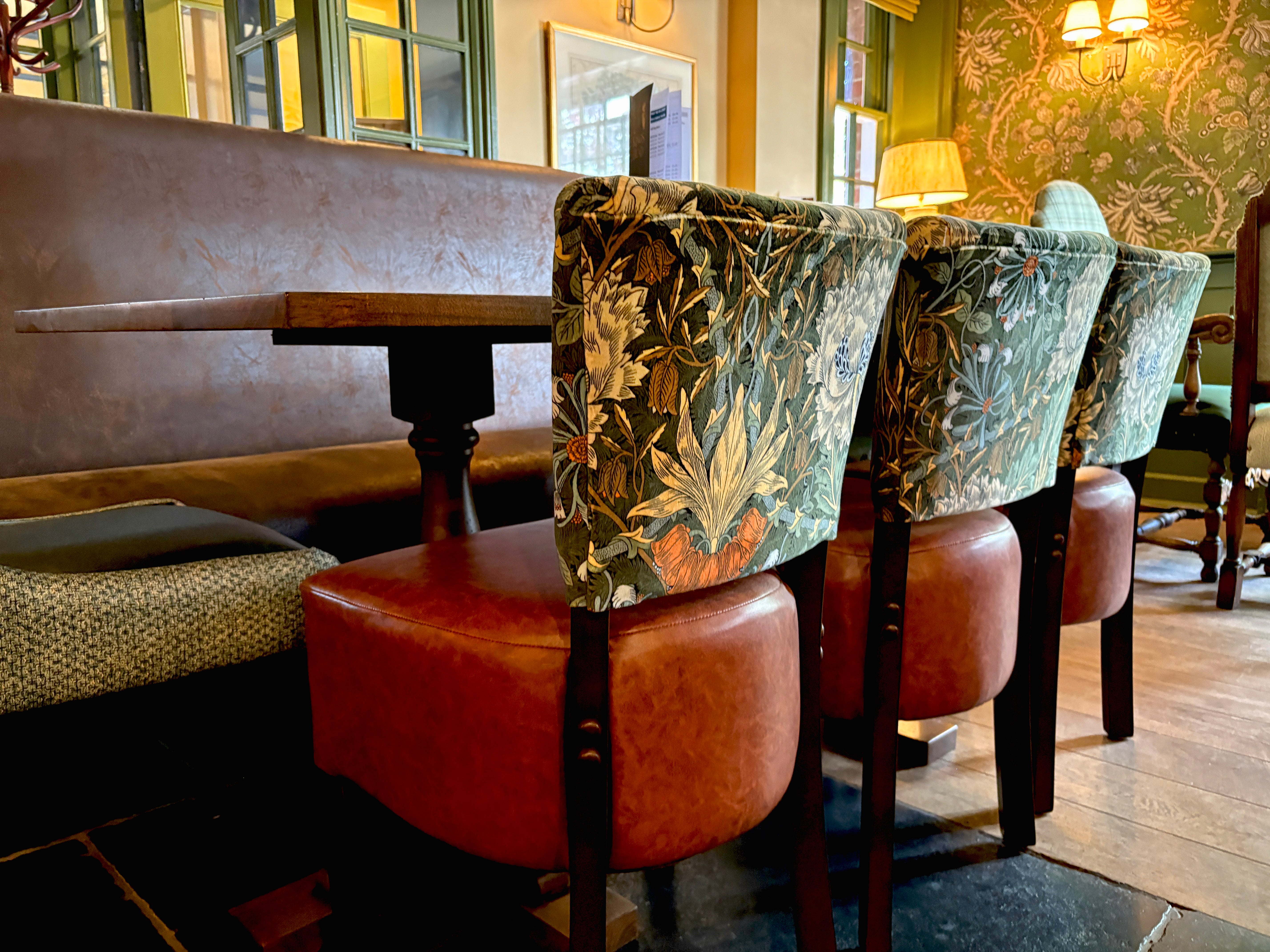 Luigi dining chairs at a rectangle table. Green floral Morris and Co fabric with a tan vinyl seat